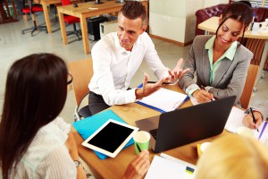 Happy business people having meeting around table in office