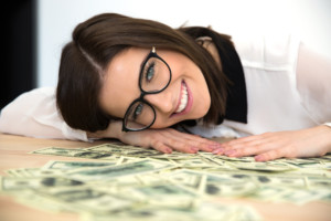 Happy woman sitting at the table with money