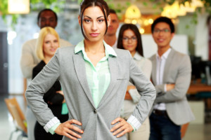 Serious beautiful businesswoman standing in front her colleagues