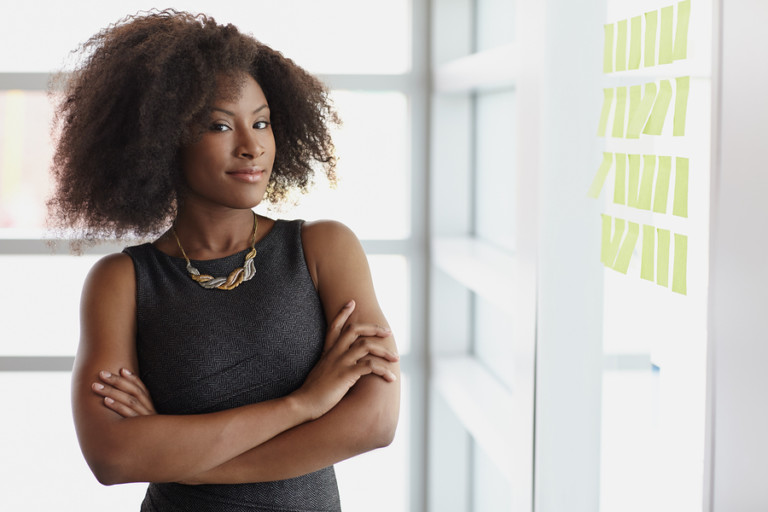 Portrait of a smiling business woman with an afro in bright glas