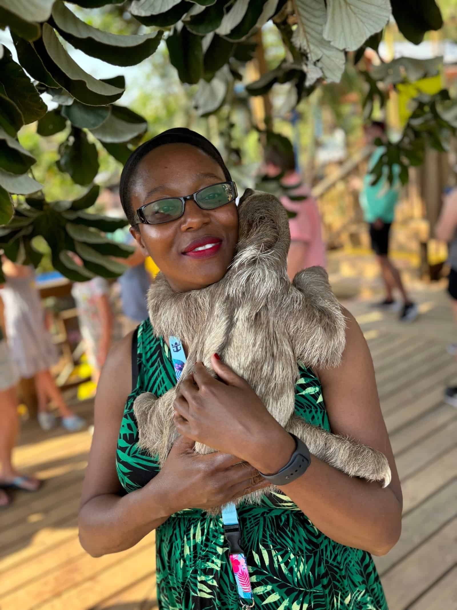 Renee Davis smiling while holding a sloth during a trip to Honduras